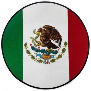 May include: A circular embroidered patch featuring the Mexican flag. The flag is green, white, and red with the Mexican coat of arms in the center. The coat of arms depicts a golden eagle perched on a cactus with a snake in its beak.