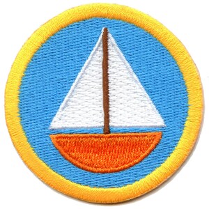 Könnte beinhalten: Ein gestickter Aufnäher in Gelb und Blau mit einem weißen Segelboot mit orangefarbenem Rumpf.