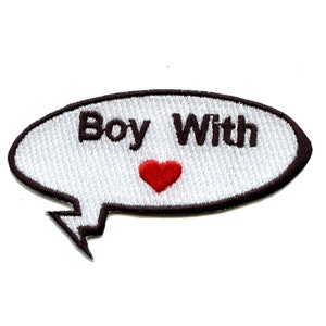 Può includere: Un fumetto bianco con contorno nero, contenente il testo "Boy With" e un cuore rosso.
