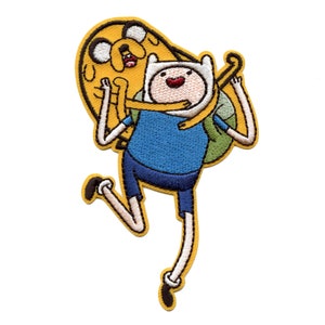 May include: Embroidered patch featuring Finn the Human from Adventure Time, wearing a blue shirt and carrying his yellow dog, Jake, on his back.