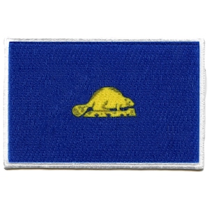 Op de afbeelding: Een blauwe stoffen patch met een witte rand en een geel beversilhouet in het midden.