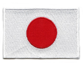 May include: A white embroidered patch with a large red circle in the centre, representing the flag of Japan.