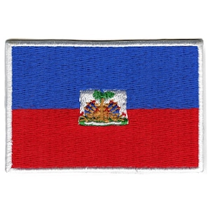 May include: An embroidered patch of the Haitian flag. The flag is blue and red with a coat of arms in the center. The coat of arms features a palm tree, a shield, and a banner.