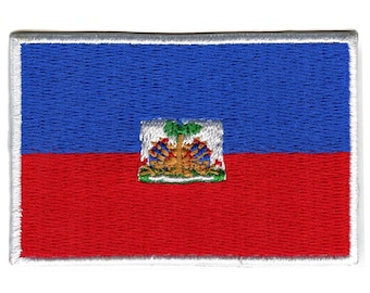 May include: An embroidered patch of the Haitian flag. The flag is blue and red with a coat of arms in the centre. The coat of arms features a palm tree, a shield, and a banner.