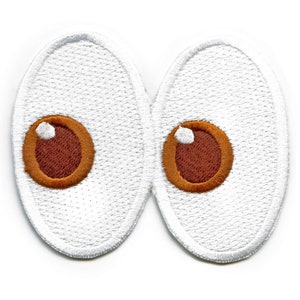 Può includere: Un paio di occhietti buffi in feltro bianco con pupille marroni. Gli occhi sono cuciti insieme e hanno una forma leggermente ovale.