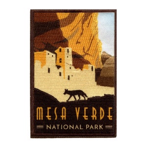 May include: A brown and tan embroidered patch featuring the text "Mesa Verde National Park" and a silhouette of a coyote in front of a cliff dwelling.