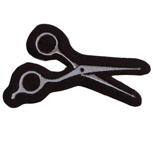 May include: Black fabric patch with a white embroidered design of a pair of scissors.