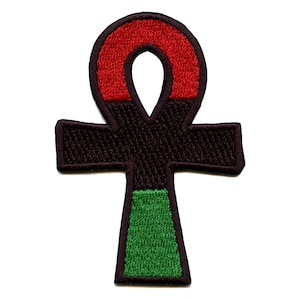 May include: An embroidered patch in the shape of an Ankh, a symbol of life in ancient Egypt. The Ankh is red, black, and green, representing the colors of the Pan-African flag.