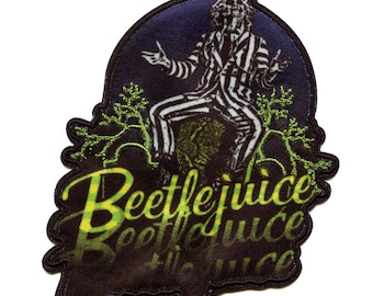 May include: A black and green embroidered patch featuring a cartoon character sitting on a rock with the text "Beetlejuice" written in a stylised font.