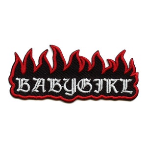 May include: Black and white embroidered patch with the text "BABY GIRL" in a gothic font. The patch is surrounded by red flames.