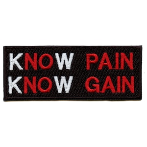 Pode incluir: Um patch retangular preto com texto bordado em branco e vermelho. A linha superior diz "KNOW PAIN" e a linha inferior diz "KNOW GAIN". O patch tem uma aparência texturizada.