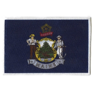 May include: A blue patch with a white border, featuring the state seal of Maine. The seal depicts a pine tree, two figures, and the Latin phrase "Dirigo", meaning "I guide". The words "Maine" are written in a gold banner below the seal.
