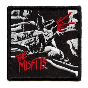 Könnte beinhalten: Schwarzer und weißer gestickter Patch mit dem Bandnamen "The Misfits" in roten Buchstaben. Der Patch zeigt eine Grafik einer Person mit blutigem Kopf.