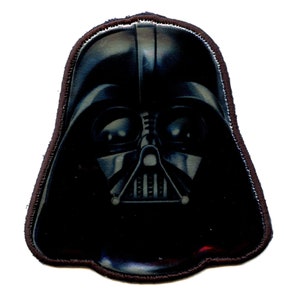 May include: A black and silver Darth Vader character patch with a dark background. The patch is made of fabric and has a stitched border.