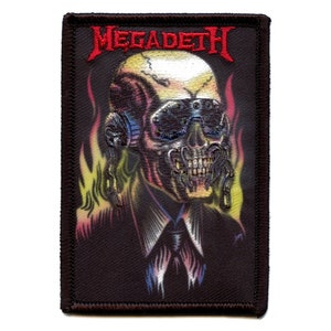 May include: A black embroidered patch with a skull wearing sunglasses and a tie. The skull is surrounded by flames. The text "Megadeth" is in red above the skull.