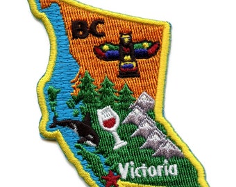 May include: Embroidered patch shaped like the province of British Columbia, Canada. The patch features a stylized image of a totem pole, a glass of wine, an orca whale, and a mountain range. The words "BC" and "Victoria" are also embroidered on the patch.