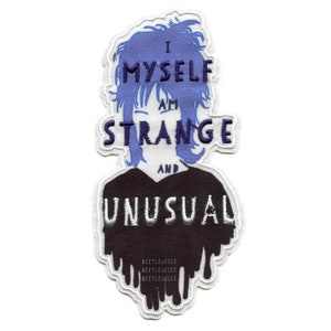 May include: An embroidered patch featuring a cartoon character with blue hair and the text "I Myself Am Strange And Unusual". The character is wearing a black shirt with dripping edges that say "Beetlejuice" in white text.
