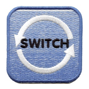 May include: Blue square patch with white stitching around the edges. A white circle with two white arrows pointing in opposite directions is in the center of the patch. The word "SWITCH" is in black letters inside the circle.