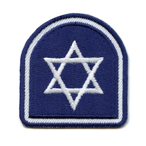 May include: A blue fabric patch with a white six-pointed star in the center. The patch has a white border.