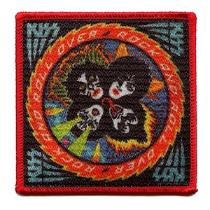 Op de afbeelding: Een rood, zwart en wit geweven patch met de woorden "KISS" en "Rock and Roll Over" in een cirkel rond vier zwart-witte gezichten.