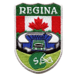 Könnte beinhalten: Gestickter Aufnäher mit dem Wort "REGINA" in grünen Buchstaben auf weißem Hintergrund. Der Aufnäher zeigt außerdem eine kanadische Flagge mit einem roten Ahornblatt, ein blaues und weißes Stadion und einen grünen Footballhelm.