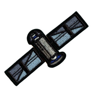 May include: A black and blue embroidered patch featuring a satellite in space. The satellite is silver with a blue and white stripe on the side. The patch is ideal for adding a touch of space exploration to your belongings.