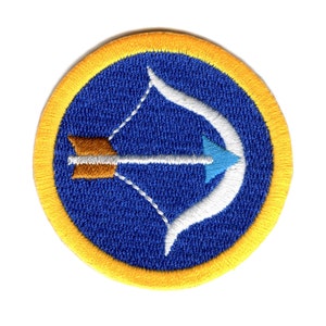 May include: A blue and yellow embroidered patch with a white bow and arrow design. The arrow is brown and blue.