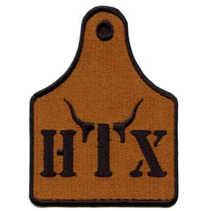 May include: A brown patch with a black border, featuring the letters "HTX" and a bull's head silhouette. The patch has a rectangular shape with a rounded top and a small hole.