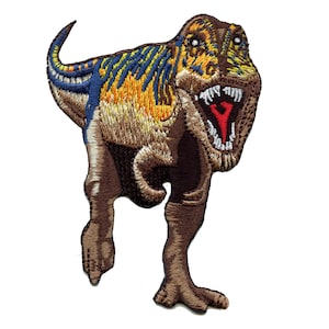 Può includere: Toppa ricamata di un dinosauro Tyrannosaurus Rex marrone, giallo e blu con la bocca aperta rossa e denti bianchi. Il dinosauro è in piedi sulle zampe posteriori con la coda alzata.