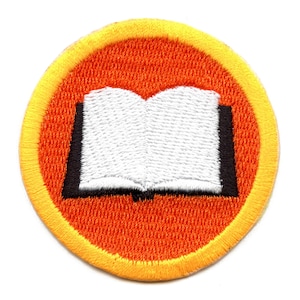 May include: A round, orange embroidered patch with a yellow border. The patch features a white open book with black edges.