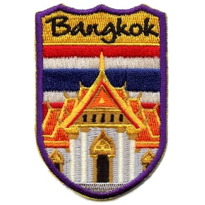 May include: An embroidered patch with a purple border, featuring a gold and orange temple with the Thai flag behind it. The text "Bangkok" is embroidered in black on a gold background.