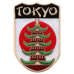 May include: Embroidered patch with a white background and a tan border. The patch features a red circle with a stylised pagoda in the centre. The text "TOKYO" is above the circle in black.