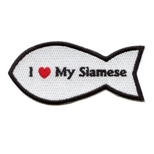Op de afbeelding: Witte geborduurde strijkpatch in de vorm van een vis met een zwarte omtrek. De patch zegt "Ik hou van mijn Siamese" met een rood hart.
