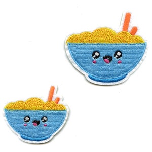 Pode incluir: Dois patches bordados para passar a ferro de um prato azul com uma cara sorridente e macarrão amarelo dentro. O prato tem pauzinhos laranja que sobressaem.