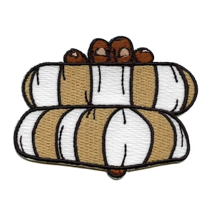 May include: A brown and white embroidered patch depicting a stack of three logs with a hand on top. The logs are brown with white stripes and the hand is brown with white fingernails.