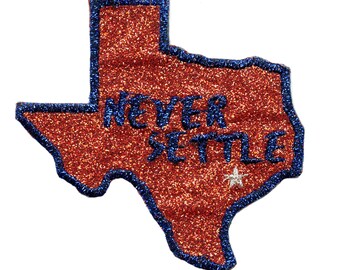 May include: A red glitter outline of the state of Texas with a blue border and the words "Never Settle" in blue lettering. A white star is in the lower right corner.