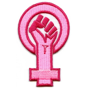 Puede incluir: Parche bordado rosa con un puño en alto dentro de un símbolo femenino.
