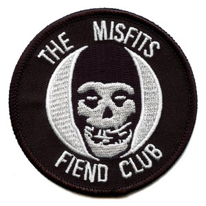 May include: A black and white embroidered patch with the text "The Misfits Fiend Club" and a skull with a hooded face.