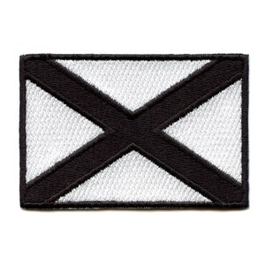 May include: Embroidered patch featuring a white background with a black X-shaped design. The patch has a black border and is rectangular in shape. The design is a stylized flag.