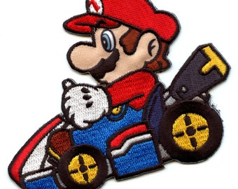 May include: An embroidered patch featuring Mario from the Super Mario Kart video game series. Mario is depicted wearing his signature red cap and overalls, driving a blue kart with yellow wheels. The patch is perfect for adding a touch of nostalgia to jackets, bags, or other items.