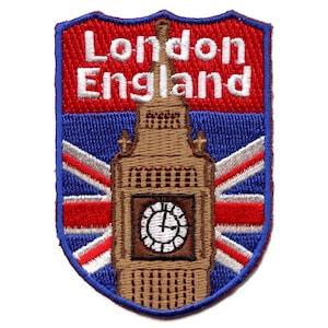 May include: An embroidered patch featuring the iconic Big Ben clock tower in London, England. The patch is shaped like a shield and has a red, white, and blue Union Jack flag design. The text "London England" is embroidered in white on a red background.