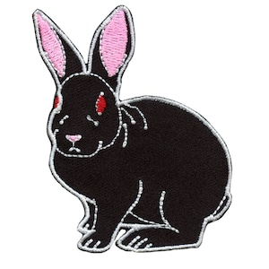 May include: Black embroidered rabbit patch with pink ears and red eyes. The rabbit is sitting with its front paws tucked under its body.