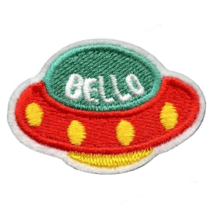 Peut inclure: Un patch brodé en forme de soucoupe volante, de couleur rouge et verte, avec le mot "BELLA" en lettres blanches sur le dessus.