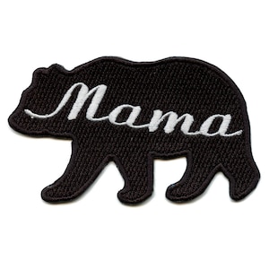 May include: A black bear-shaped patch with the word "Mama" embroidered in white cursive script. The patch is likely made of fabric and designed to be sewn or ironed onto clothing or accessories.