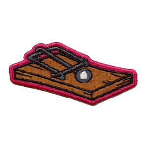 May include: A brown wooden mousetrap with a black metal spring and a white bait. The mousetrap is outlined in pink.