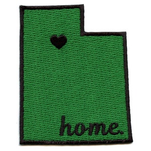 May include: Green embroidered patch shaped like the state of Utah with a black heart and the word "home" in black lettering.