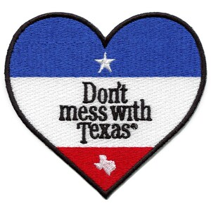 Op de afbeelding: Een rood, wit en blauwe hartvormige patch met een witte ster en de tekst "Don't mess with Texas" in zwart. De omtrek van de staat Texas is in wit op een rode achtergrond aan de onderkant van de patch.