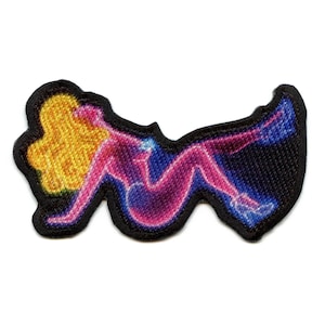 Pode incluir: Patch bordado com uma figura estilizada em rosa e azul, com cabelo amarelo e contorno preto. O patch tem uma borda preta, projetado para ser aplicado em roupas ou acessórios.