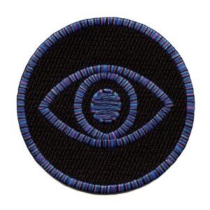 May include: A round, black embroidered patch with a blue, purple, and green eye design.