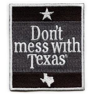 May include: Embroidered patch with the phrase "Don't mess with Texas" in white lettering. The patch features a white star at the top and a white outline of Texas at the bottom. The background is a textured gray with black and white borders.